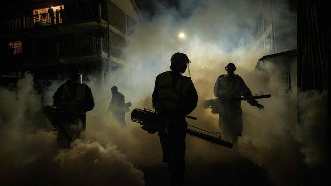 Volunteers from Sonko Rescue Team fumigate a street to curb the spread of COVID-19 during a 7pm-5am curfew in Nairobi, Kenya, in April. Picture: AFP