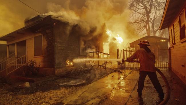 A firefighter battles the Eaton Fire Wednesday, Jan. 8, 2025 in Altadena, Calif. (AP Photo/Ethan Swope)