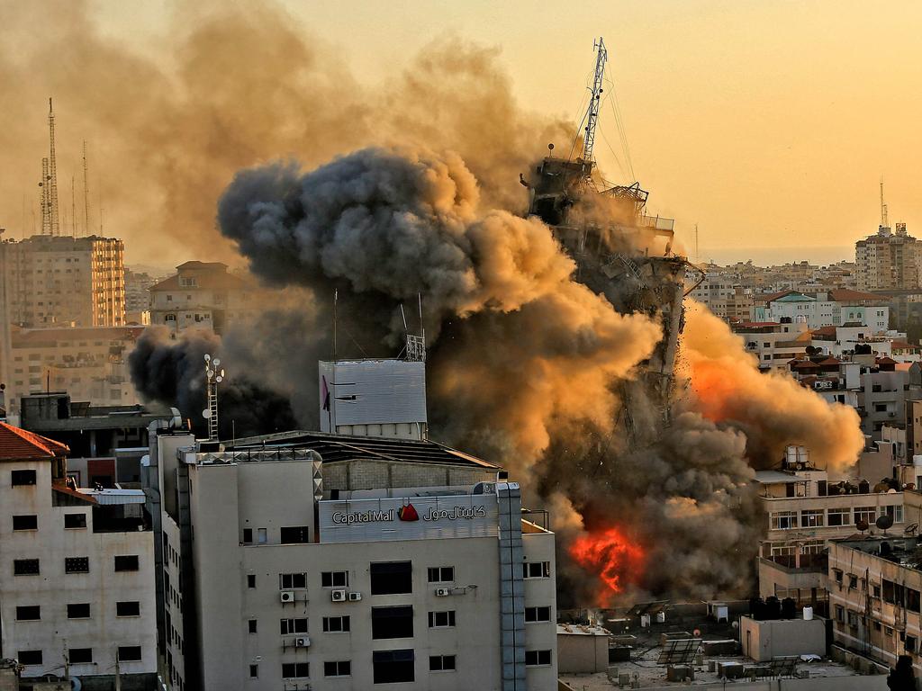 Heavy smoke and fire rise from Al-Sharouk tower as it collapses after being hit by an Israeli air strike, in Gaza City. Picture: AFP