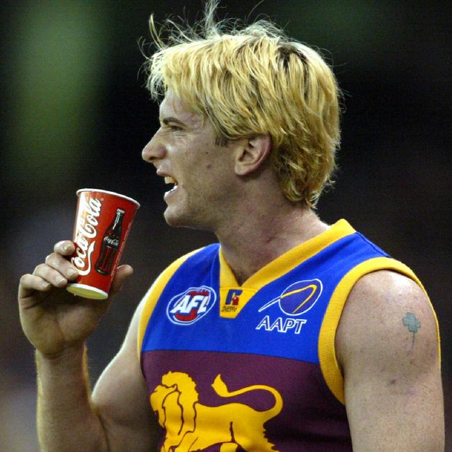 Jason Akermanis drinks out of a Coca-Cola cup during a game.