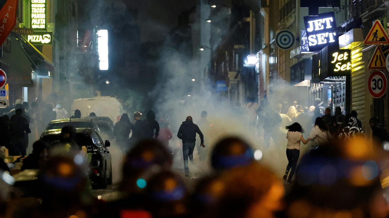 Demonstrators run as French police officers use tear gas in Paris. Picture: Ludovic Marin / AFP