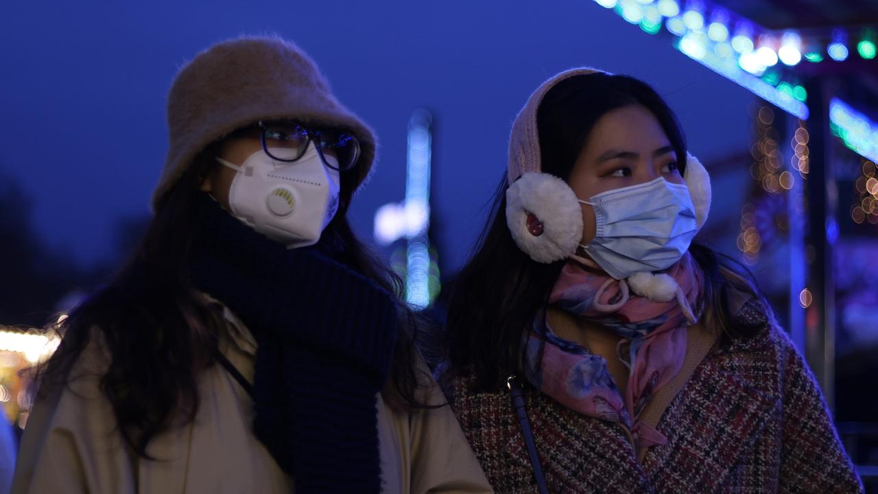 People wear face coverings at Hyde Park Winter Wonderland in London.