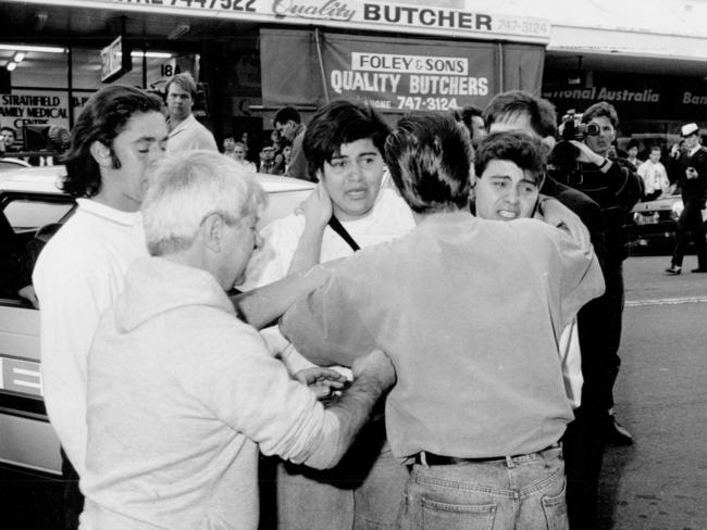 Witnesses comfort each other at the scene of the shooting at Strathfield Plaza.