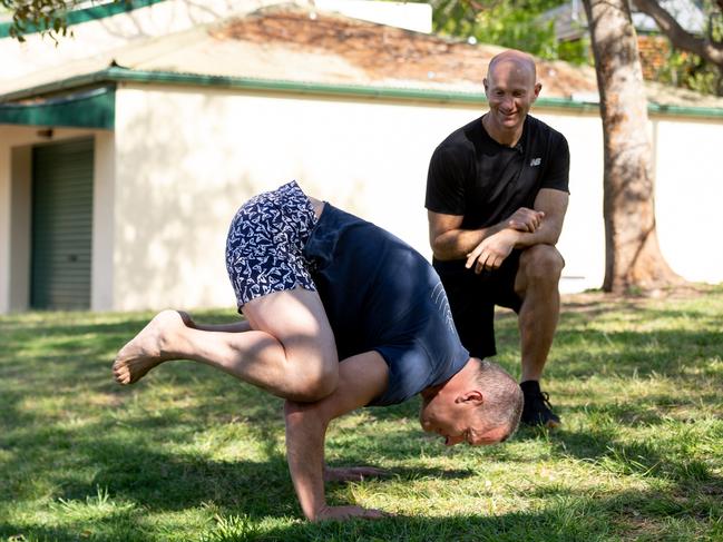 Kieran Gilbert shows Adam MacDougall some of his yoga moves. Picture: Ray Bartholomeusz