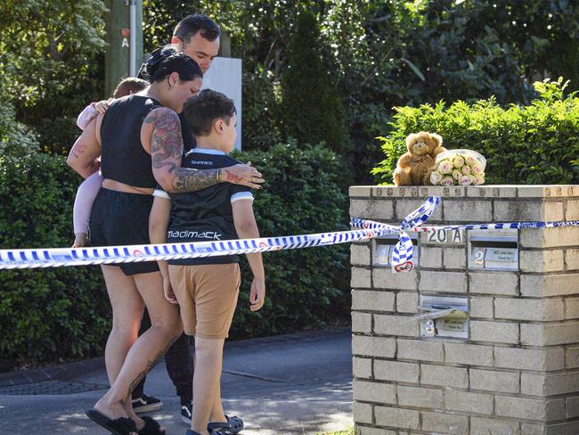 Neighbours leave flowers and a teddy near the scene on Thursday. Picture: Kevin Farmer
