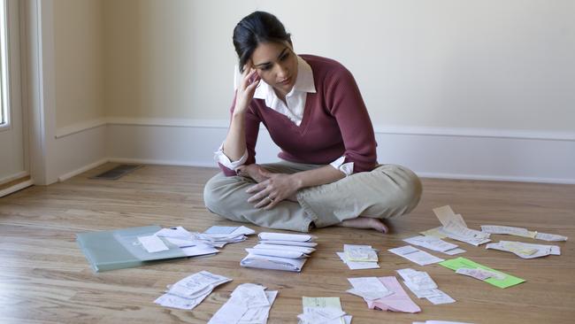 MONEYSAVERHQ .. Woman looking at bills and receipts on floor