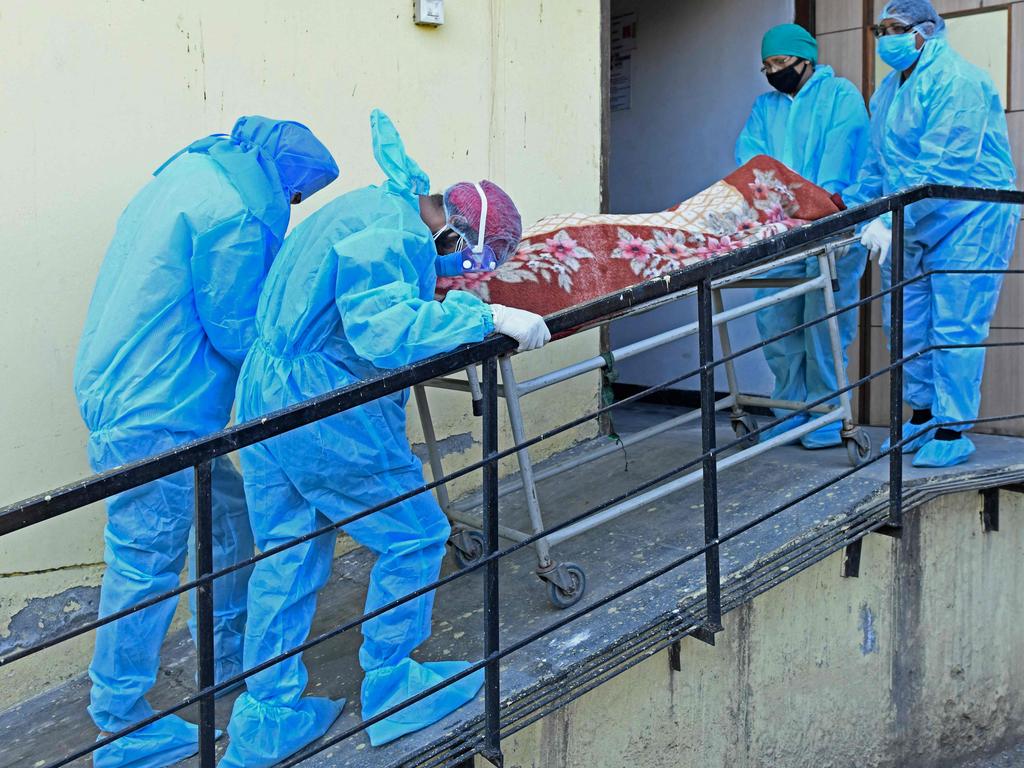 Members of medical staff wearing protective gear carry the dead body of a coronavirus victim at a hospital in India. Picture: AFP