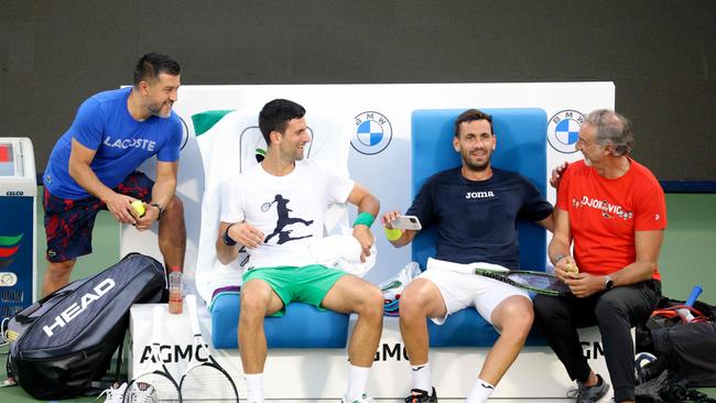 Djokovic shares a laugh with his team after a training session in Dubai. Picture: AFP