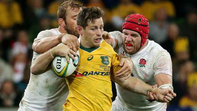 Bernard Foley is tackled by Chris Robshaw and James Haskell in Melbourne. Picture: Colleen Petch.