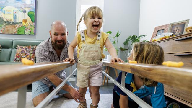 Tallulah Moon doing her walking physio at home with the help of dad, Chris, and big brother, Finn. Picture: Lachie Millard