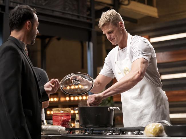 Nick Riewoldt working away in the MasterChef kitchen as judge Andy Allen offers some advice. Picture: Courtesy of Channel Ten