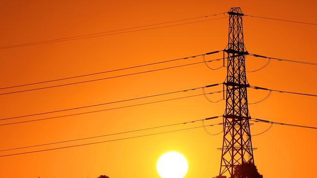 The sun sets behind powerlines in the west of Melbourne, Victoria. *power, electricity, energy* Picture: Mark Stewart