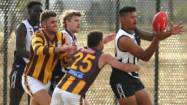 Justin Aiulu juggles the ball under pressure from Josh Pound. Picture: Hamish Blair