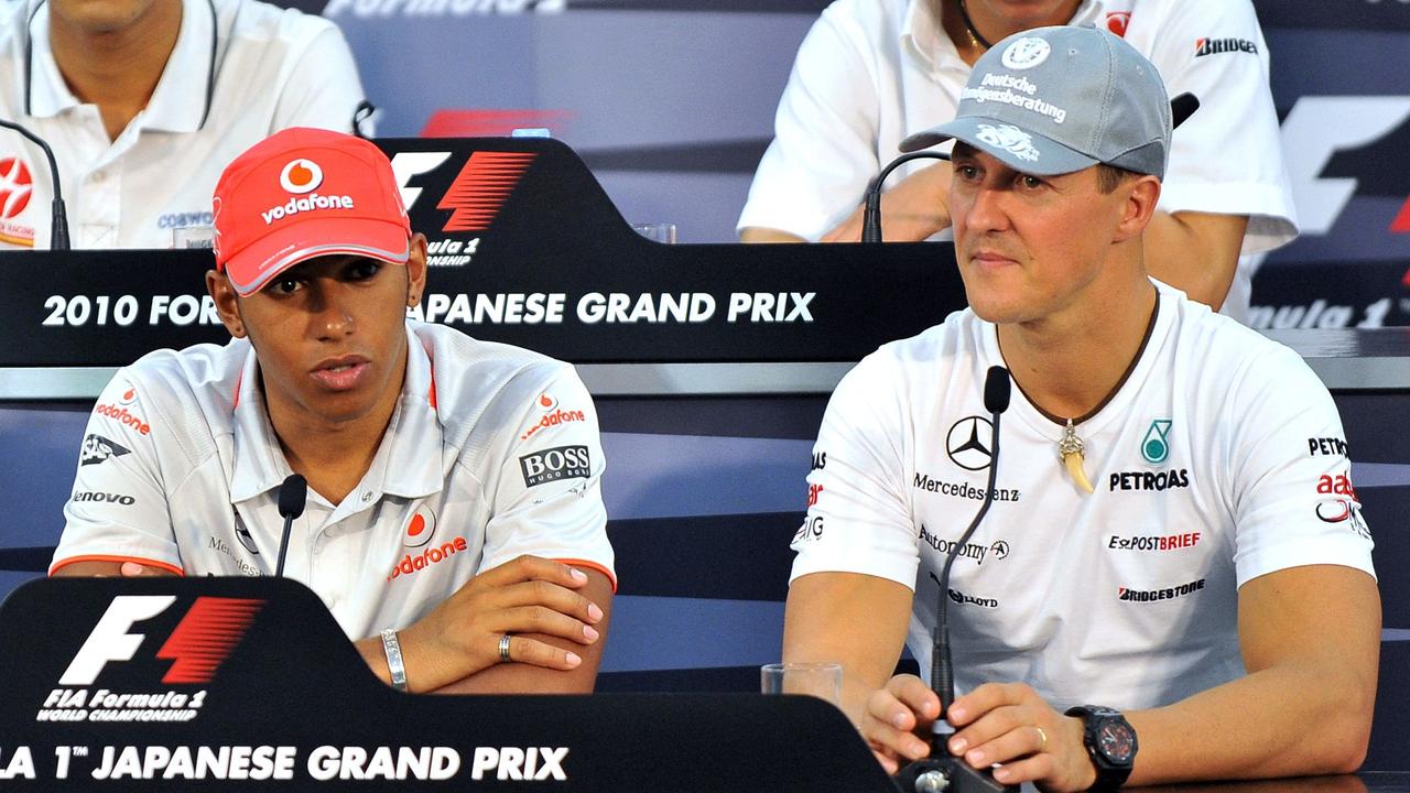 Hamilton, seen here with Michael Schumacher in 2010, has spent almost half his life in F1. (Photo by Jung Yeon-je / AFP)