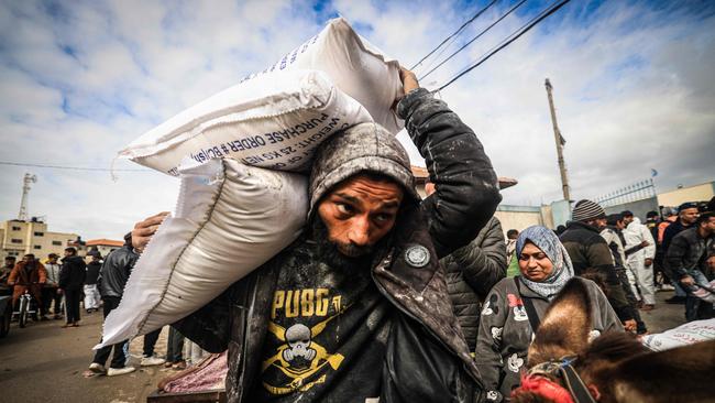 Displaced Palestinians receive food aid at the United Nations Relief and Works Agency for Palestine Refugees (UNRWA) centre in Rafah, southern Gaza. Picture: AFP