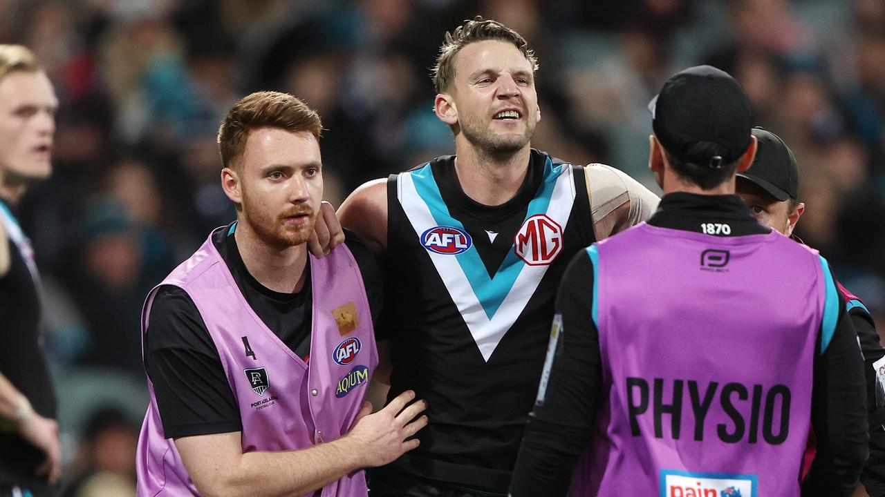 Trent McKenzie is helped from the ground. (Photo by Sarah Reed/AFL Photos via Getty Images)