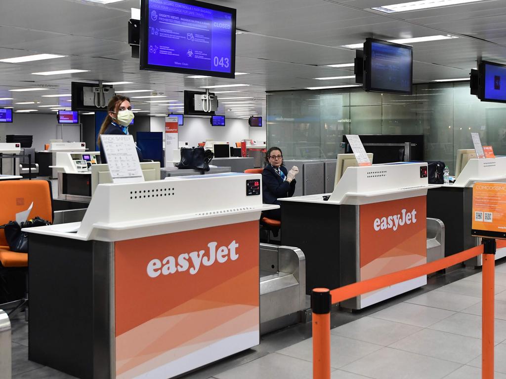 EasyJet workers wait at an empty counter in Milan, as Italy goes into lockdown over the disease. Picture: Miguel MEDINA / AFP.
