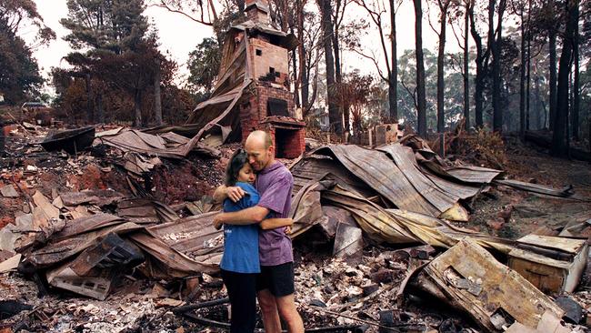 Mark and Rosemary Sims stand among gutted ruins on Mount View Rd in Ferny Creek, in the aftermath of the Dandenong Ranges’ devastating bushfires on January 22, 1997.