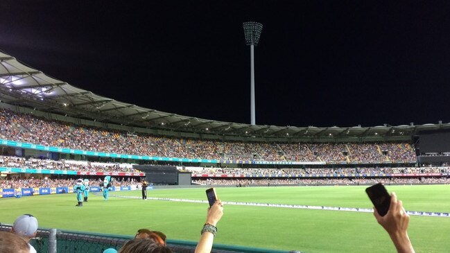 Fans at the Gabba use their phones to try to shed some light on the matter. Picture: John O'Brien