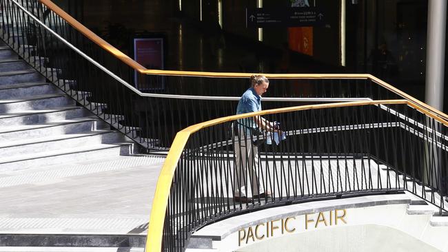 A cleaner wipes down chairs, tables and railings at Pacific Fair. Photo: Tertius Pickard