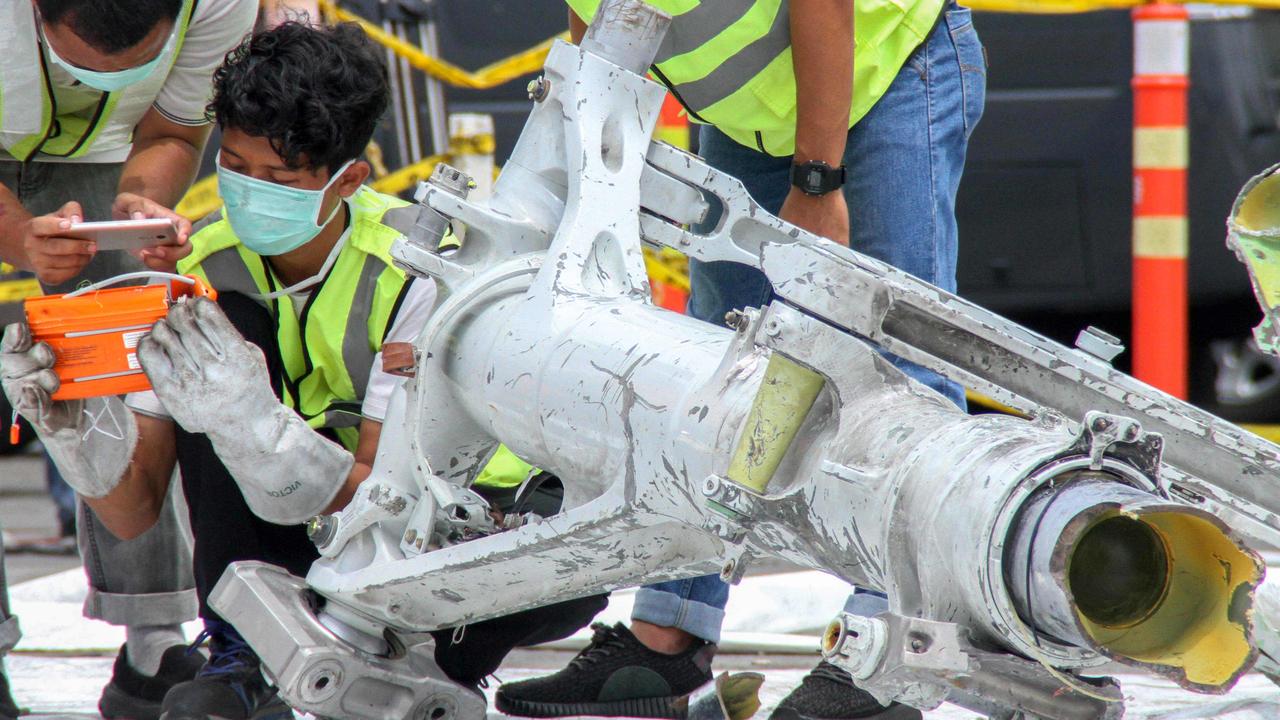 Lion Air investigators examine part of the landing gear of the ill-fated Lion Air flight JT 610 at the port in northern Jakarta. All 189 passengers died. Picture: Azwar Ipank / AFP