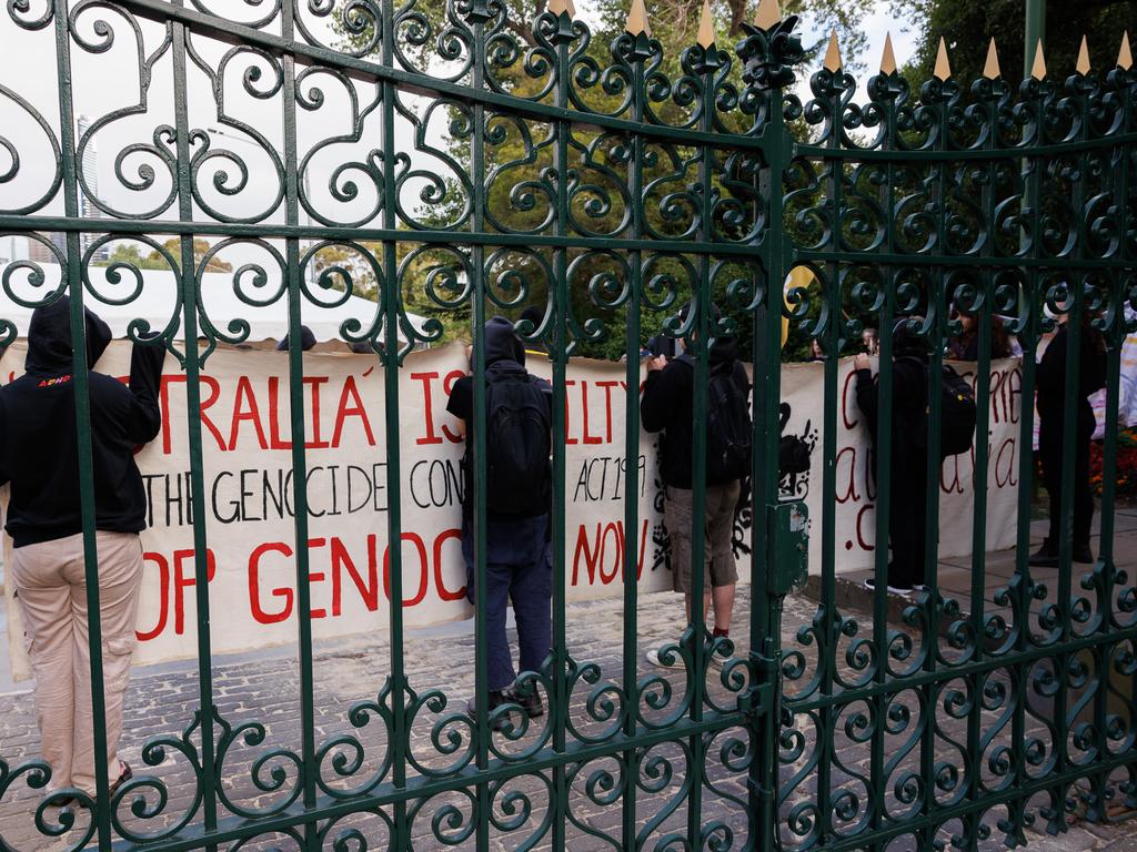 People holding signs outside Government House gates. Picture: NewsWire