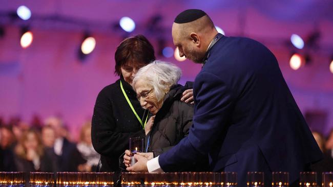 An elderly woman lays a candle during the commemorations on the 80th anniversary of the liberation of the German Nazi concentration and extermination camp Auschwitz-Birkenau.