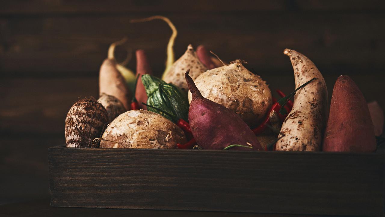 Still life of a crate of assorted vegetables shot in dark moody light