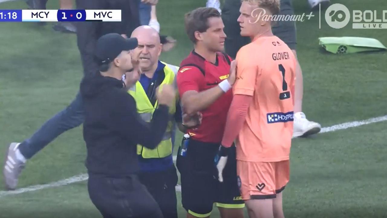 Tom Glover is helped by referee Alex as fans charge towards the Mebourne City goalkeeper. Picture: Fox Sport