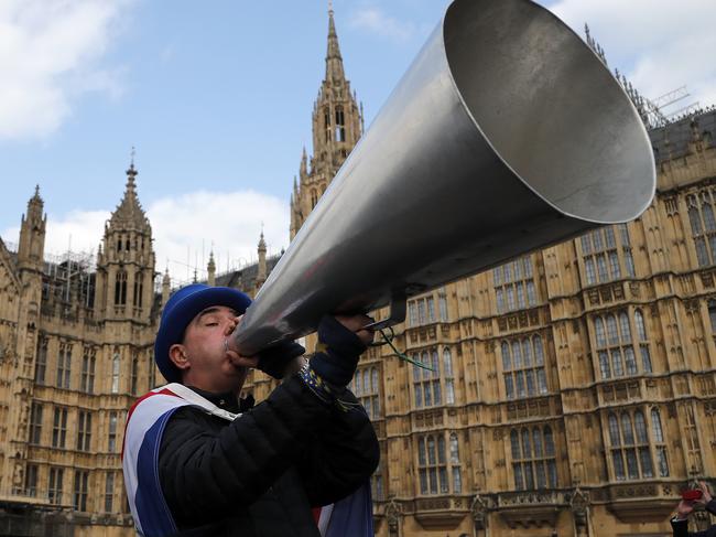 A pro EU protestor shouts through a megaphone at the Houses of Parliament in London, Wednesday, March 27, 2019. British lawmakers were preparing to vote Wednesday on alternatives for leaving the European Union as they seek to end an impasse following the overwhelming defeat of the deal negotiated by Prime Minister Theresa May. (AP Photo/Frank Augstein)