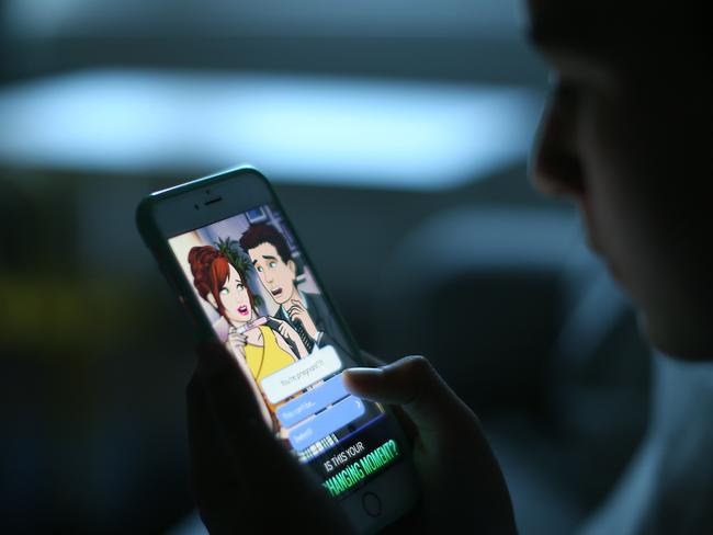 A silhouette of a young child looking at app on his phone. Pictures: Jack Tran