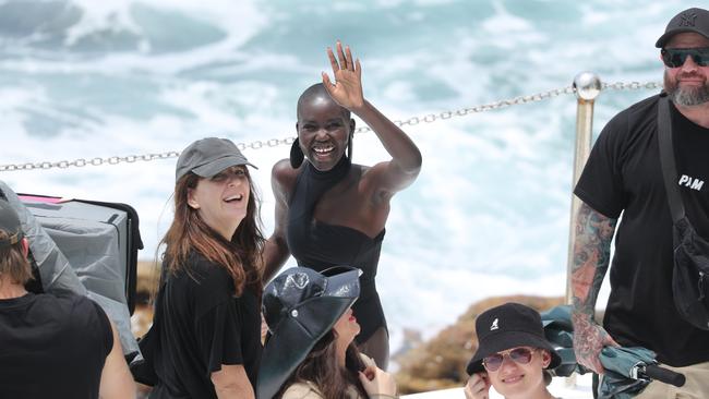 Model Adut Akech waves to punters at Bondi Icebergs during a film shot for British Vogue.