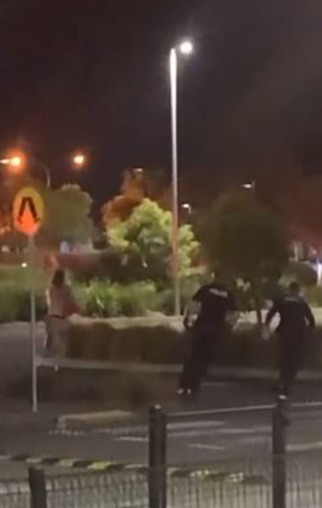 Police chase down a man at the hooning rally in Robina on Saturday night.