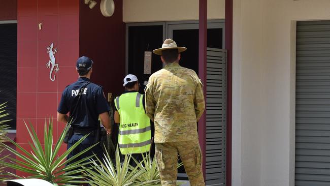 A public environmental health officer, NT police officer and Australian Defence Force member check in on a person in self-quarantine to ensure they are following regulations. PICTURE: Will Zwar