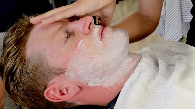 Tom Jonas takes his turn in the barber’s chair. Picture: Sam Wundke (AAP)