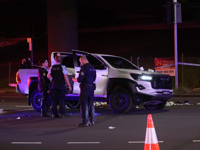 The white Toyota HiLux riddled with bullet holes is looked over by police. Picture: Rohan Kelly