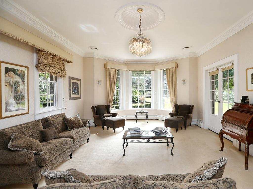 An open-plan kitchen, dining and living zone features a fireplace and window that frames views of the garden and floods the room with natural light. Picture: Andy Rogers