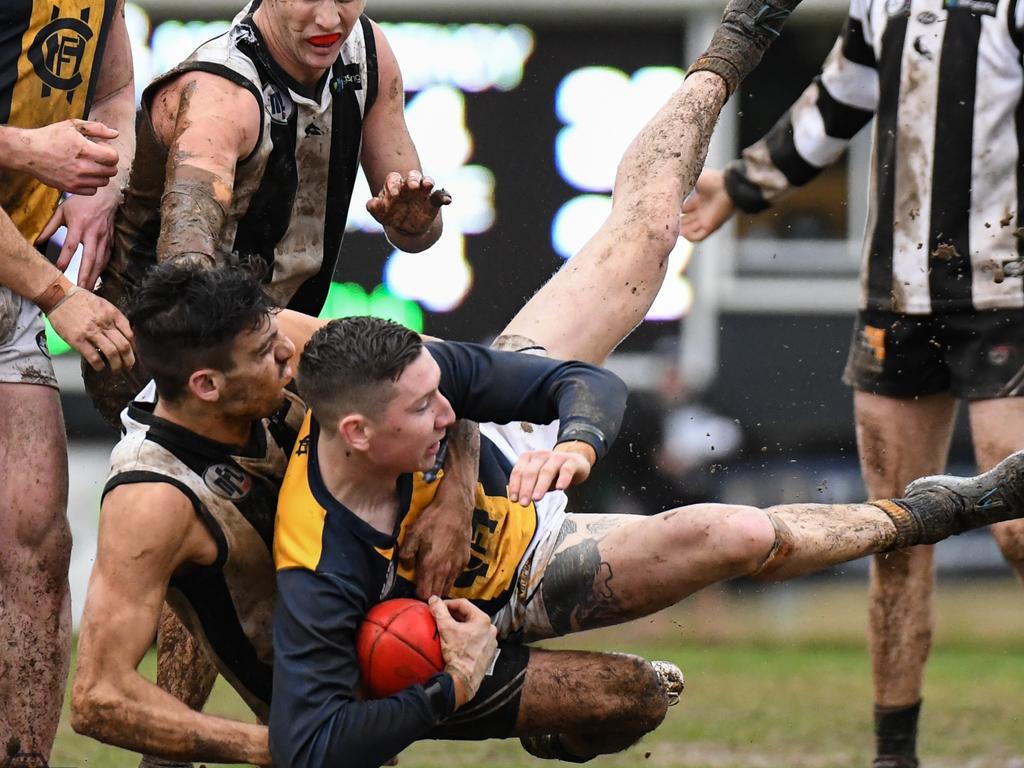 A Hurstbridge player is dumped to the ground. Pictures: Nathan McNeill.