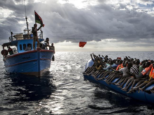 Spot News - Third Prize, Stories Picture: Mathieu Willcocks Title: Mediterranean Migration Libyan fishermen throw a lifejacket at a rubber boat full of migrants . Migrants are very often not given any life jackets or means of communication by their smugglers. More often than not they only have some water, food and not enough fuel to make it to Italy.