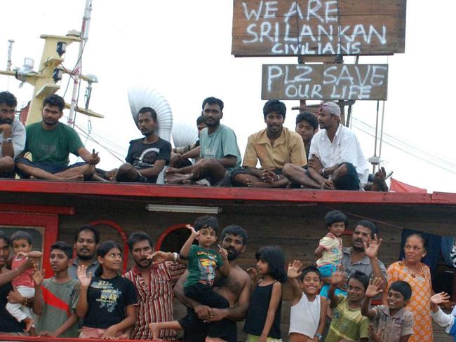 Sri Lankan assylum seekers wave from a wooden boat at a port in Cilegon, Indonesian Banten province, 13/10/2009 with Australian PM Rudd confirmed that he phoned Indonesian president for help in stopping people-smuggling shortly before their navy intercepted a boatload of 260 Sri Lankans bound for Australia.