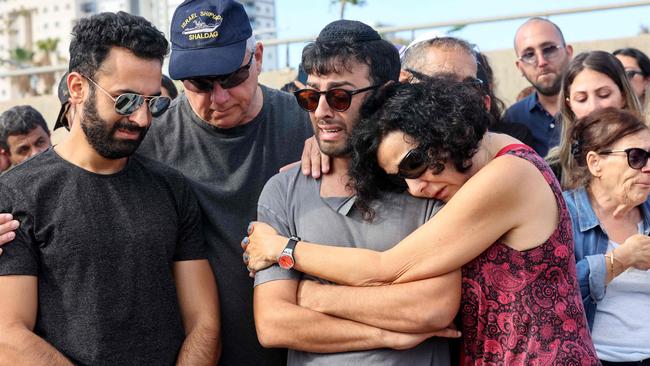 Ido, the husband of Israeli-French citizen Celine Ben David Nagar, killed during last week's attack by Hamas militants into Israel, is comforted during her funeral in Holon, south of Tel Aviv.