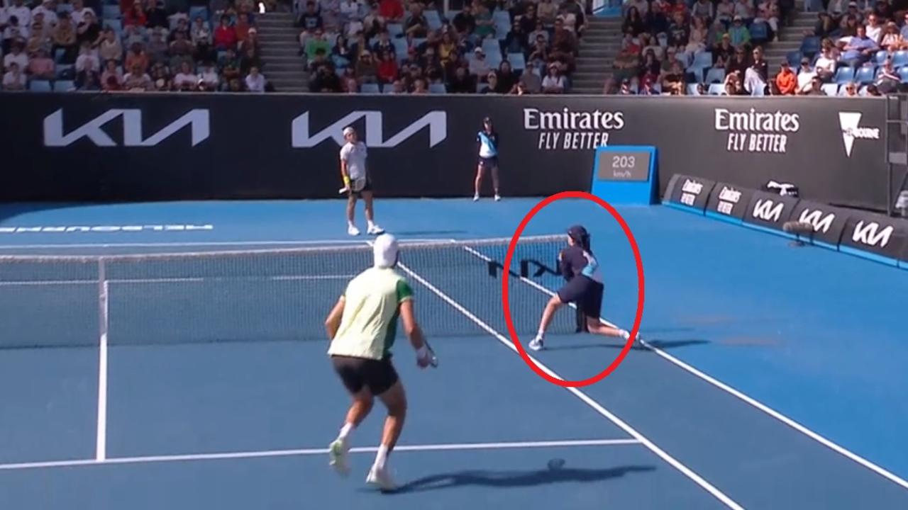 A ballkid catches a ball before it landed in play.