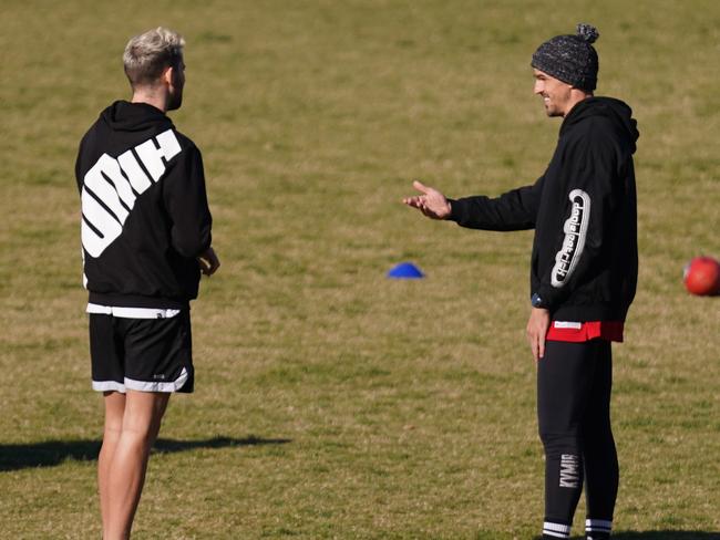 Scott Pendlebury and Jeremy Howe of the Magpies speaks to Michael Hibberd and Jake Melksham of the Demons at Elsternwick Park in Melbourne, Thursday, May 14, 2020. (AAP Image/Michael Dodge) NO ARCHIVING