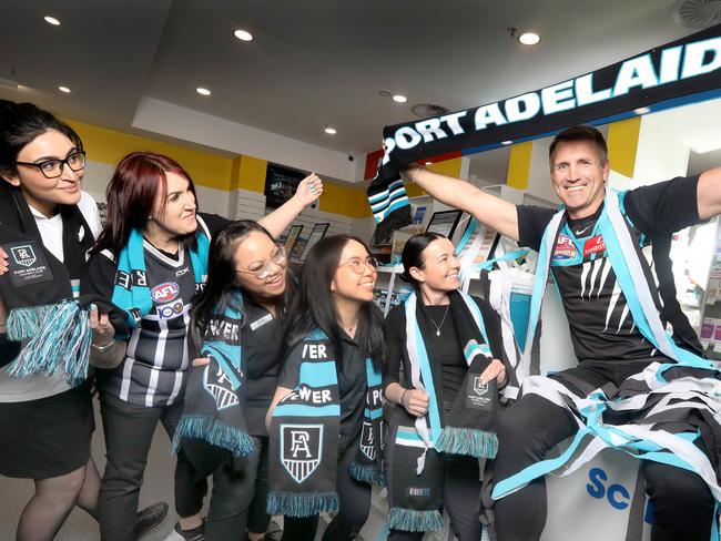 Darryl Wakelin specially attired in his 2004 premiership Guernsey, with staff at his pharmacy in Arndale, that is already decked out with Port memorabilia in readiness for finals. 8 September 2023. Picture Dean Martin