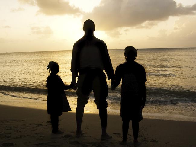 father's day theme: golden sunset beach scene of father and children silhouette