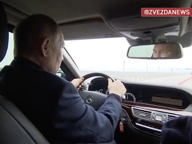 Vladimir Putin drives himself across a key Crimea bridge.