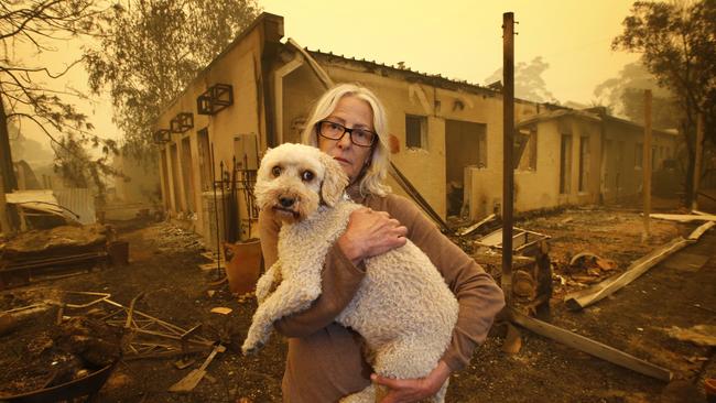 Jann Gilbert with her dog Ollie visits the site of her burnt-out unit in Mallacoota. Picture: David Caird