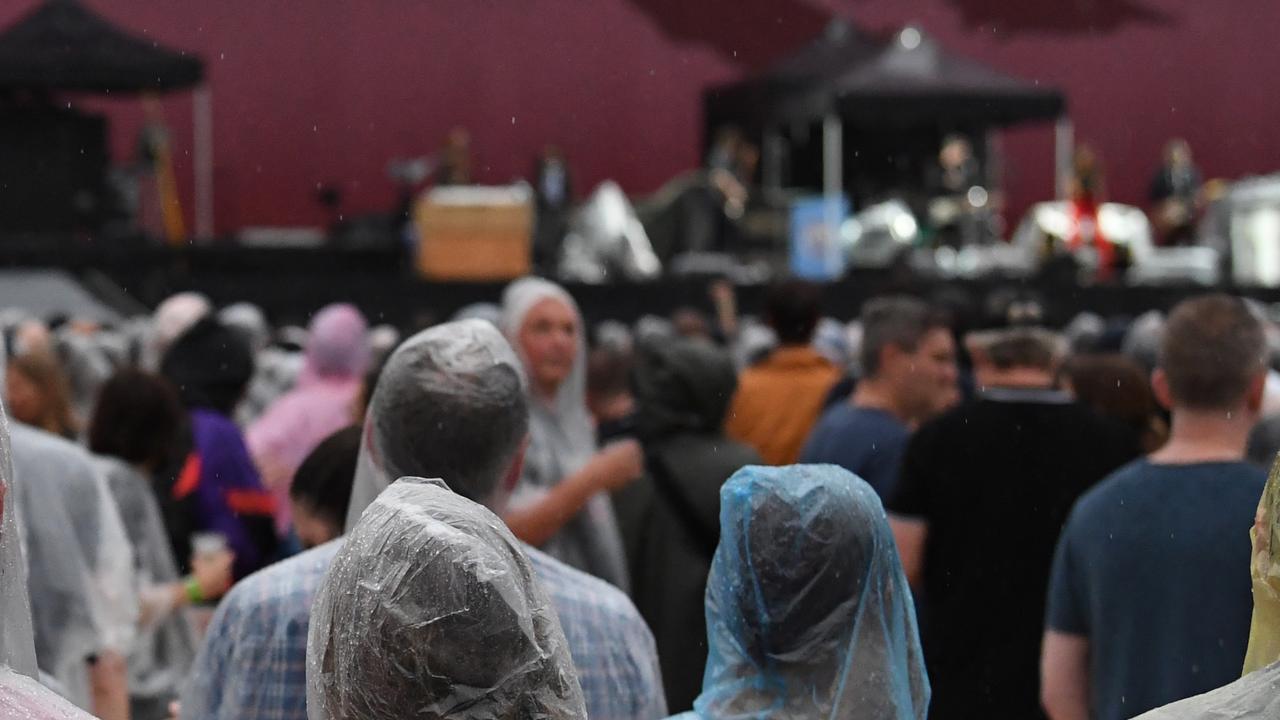 U2 fans wait in the rain for Irish rock band U2 to perform at  the SCG in Sydney, Friday, November 22, 2019. The Joshua Tree Tour 2019 has seen U2 return to New Zealand and Australia for the first time since 2010 (AAP Image/Dean Lewins) NO ARCHIVING