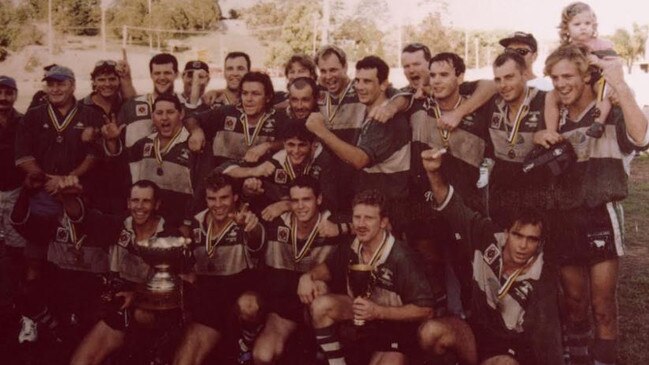 Front: Ben Toby, Brad Henderson (captain), Kerry Lamont, Dale Bond, Shane Hawes and Al Makinen. Standing: Mark Capelletti (manager), Dennis Moore (coach), Steve Atkins, Russell Benson, Lincoln Smith, Tony Henderson, Greg Wright, Paul White, Brad Letarran, Darryl Fitzgerald, Steve Moon, Mark Sippel, Trafford Jackson and Tim Abbott (conditioner) celebrate their 1998 grand final victory.