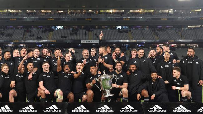 New Zealand players celebrates with the Bledisloe Cup in Auckland. Picture: Michael Bradley / AFP